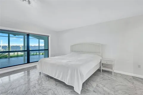 a spacious bedroom with a bed and a chandelier