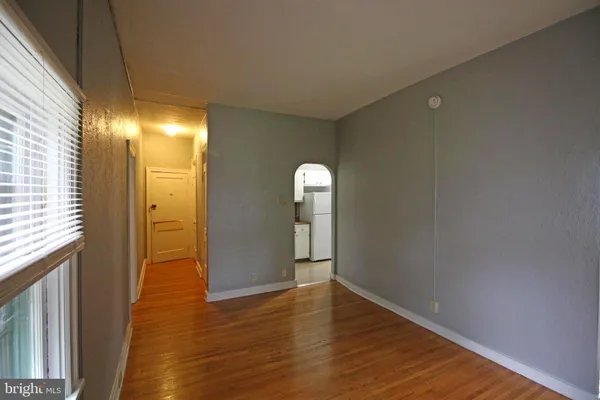 a view of empty room with window and wooden floor