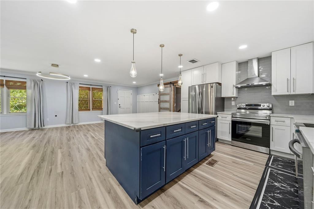 2702 Davenport Road Northwest Duluth, GA 30096 - Photo 13 of 48 a kitchen with stainless steel appliances granite countertop a large stove a sink dishwasher and a refrigerator with wooden floor