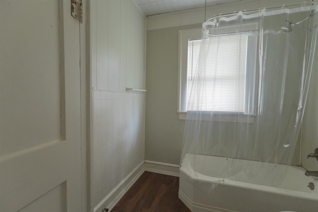 2913 Homan Avenue, Unit 2913 Waco, TX 76707 - Photo 9 of 16 Bathroom featuring wood-finish flooring, white paneled walls, and white tiled wainscoting