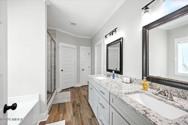 a bathroom with a granite countertop double vanity sink and a mirror