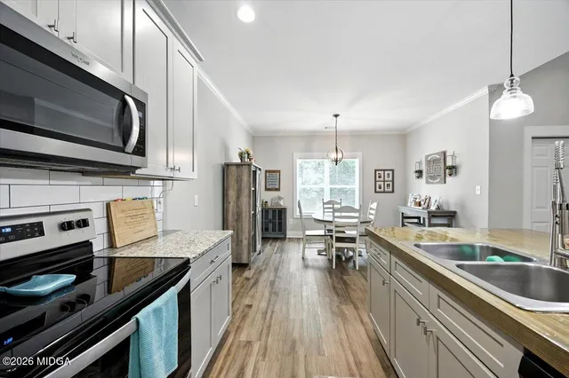 a kitchen with stainless steel appliances kitchen island granite countertop a stove a sink and a microwave