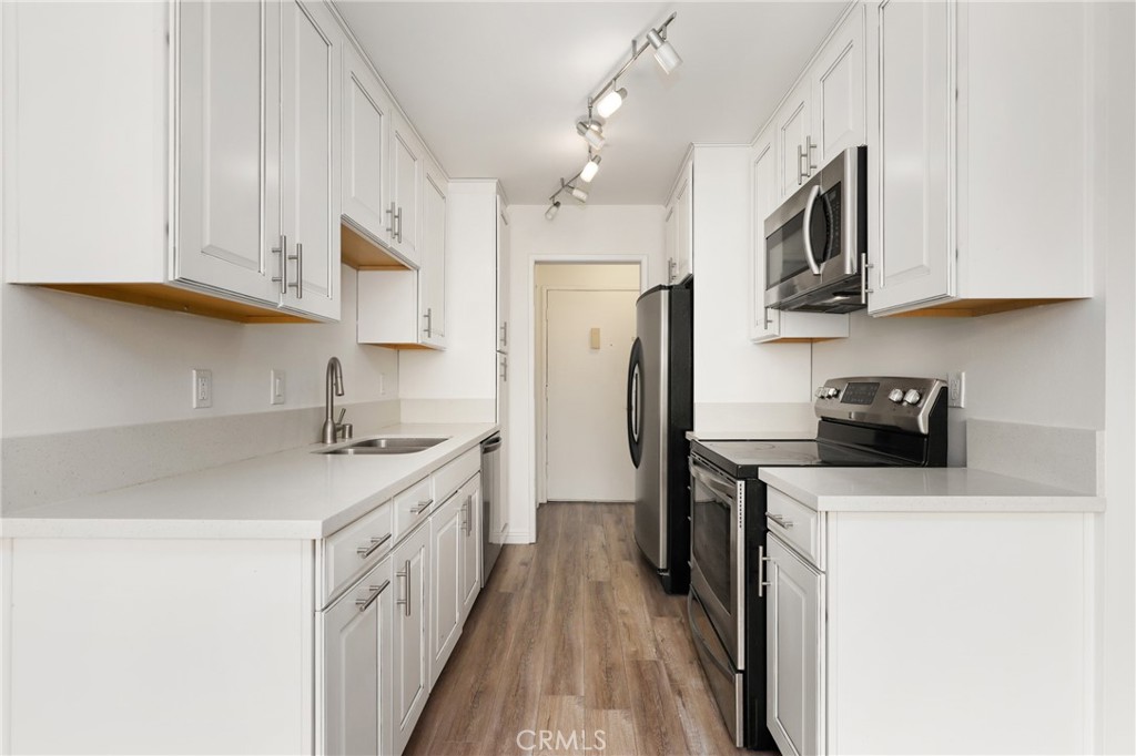 12200 Montecito Road, Unit D301 Seal Beach, CA 90740 - Photo 11 of 32 a kitchen with stainless steel appliances granite countertop a sink stove and refrigerator