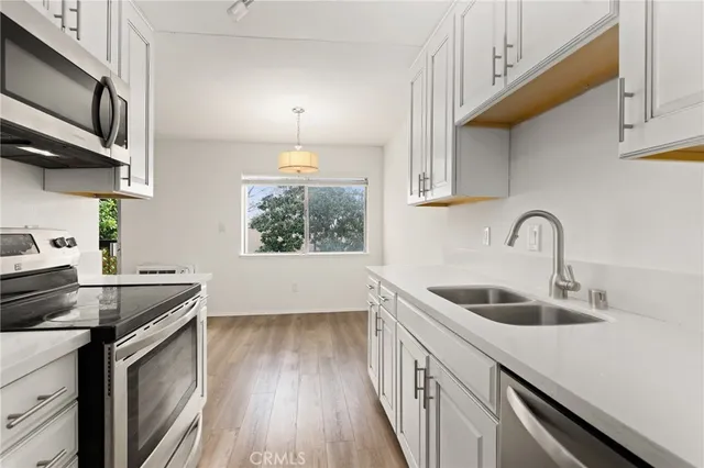 a kitchen with stainless steel appliances a sink stove and cabinets
