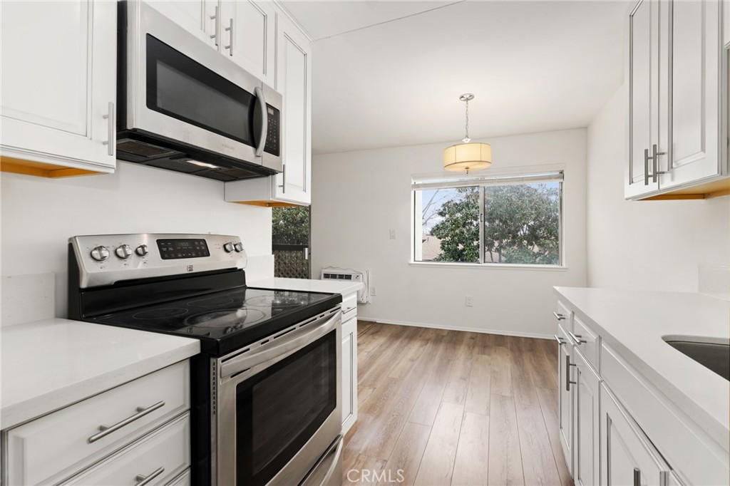 12200 Montecito Road, Unit D301 Seal Beach, CA 90740 - Photo 13 of 32 a kitchen with a stove and a microwave