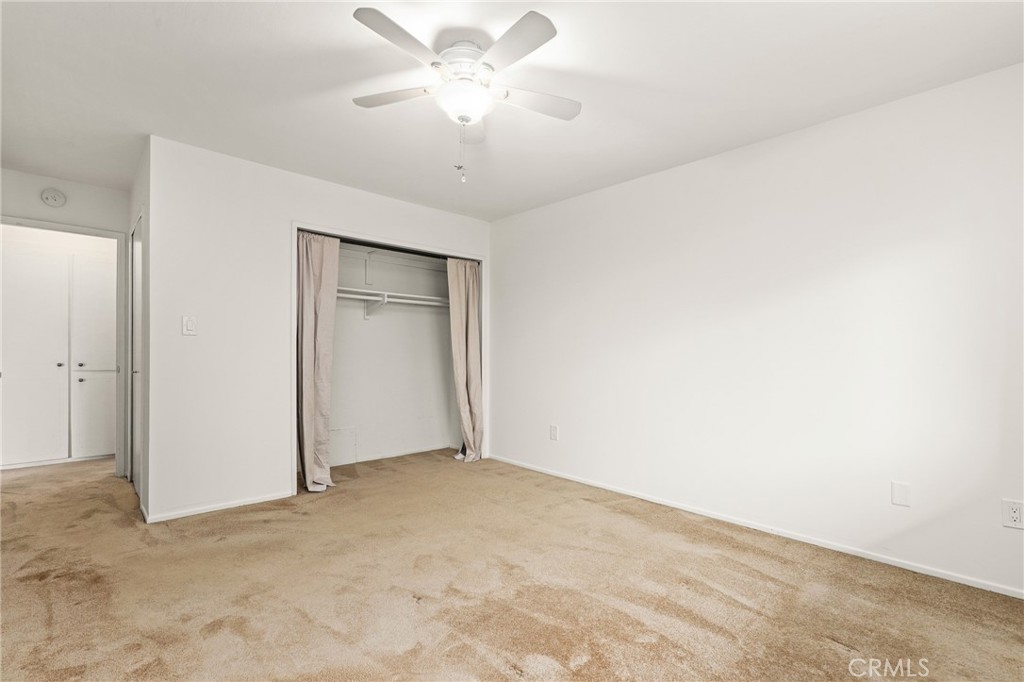 12200 Montecito Road, Unit D301 Seal Beach, CA 90740 - Photo 16 of 32 an empty room with a chandelier fan and windows