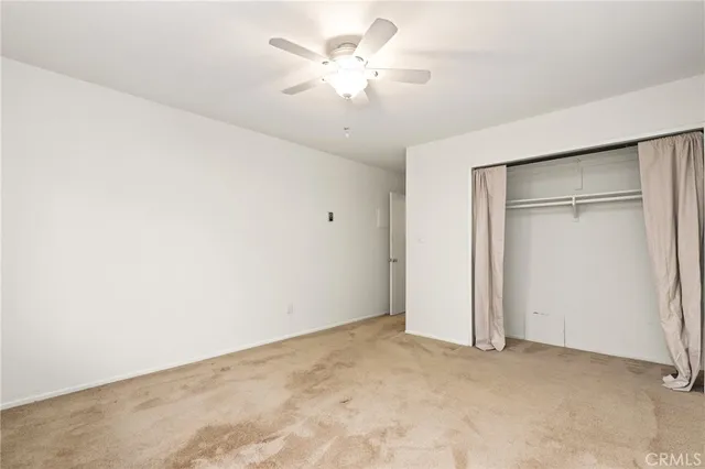 an empty room with a ceiling fan and a window