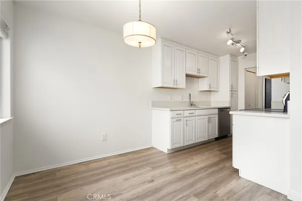 a kitchen with a white cabinets stove and wooden floor