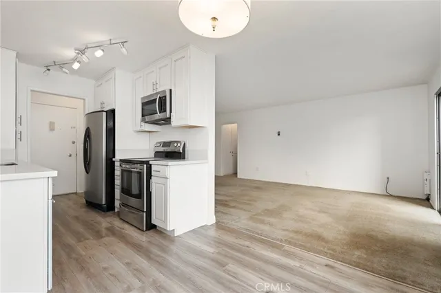 a kitchen with a refrigerator and a stove top oven