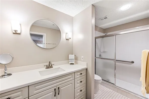 a bathroom with a sink a mirror a vanity and a shower