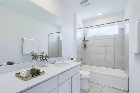 a bathroom with a granite countertop sink a toilet and shower
