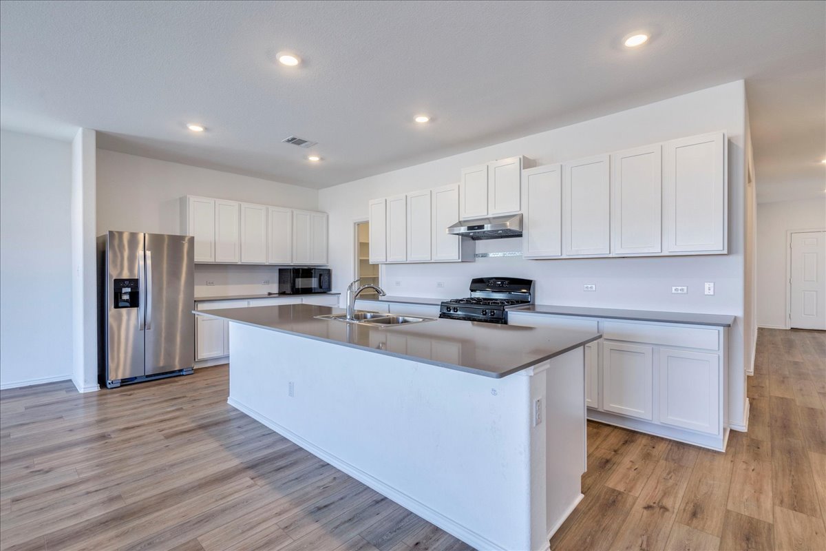 1937 Guntersville Bend Leander, TX 78641 - Photo 24 of 38 a kitchen with stainless steel appliances granite countertop a sink stove and refrigerator