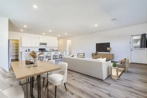 a kitchen with stainless steel appliances kitchen island granite countertop a dining table chairs and granite counter tops