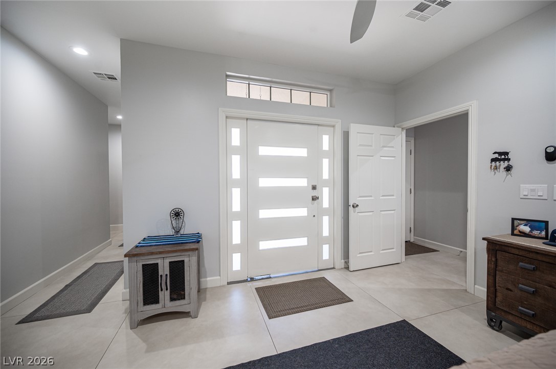 441 Belville Road Pahrump, NV 89048 - Photo 6 of 44 A striking modern entryway features a bright door with translucent panels and a spacious, tile-floored foyer.