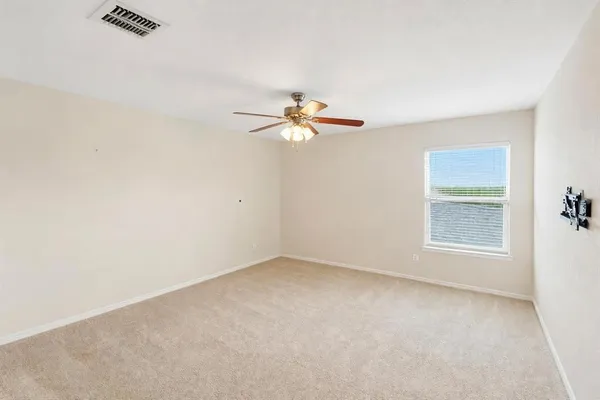 an empty room with a window and a fan