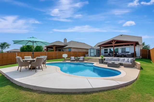 a view of house with swimming pool yard fire pit and outdoor seating