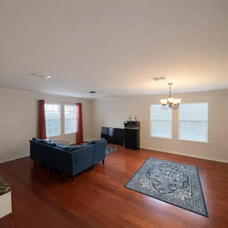 a living room with furniture and wooden floor