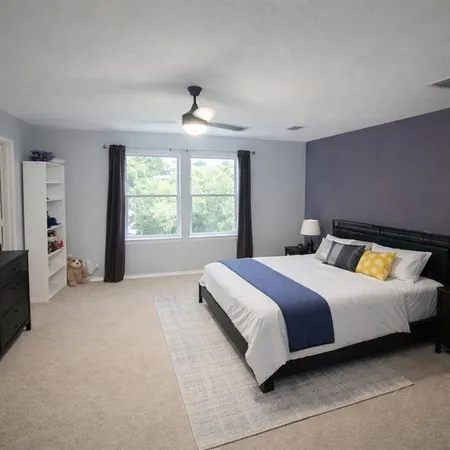 a bedroom with a large bed and a large window