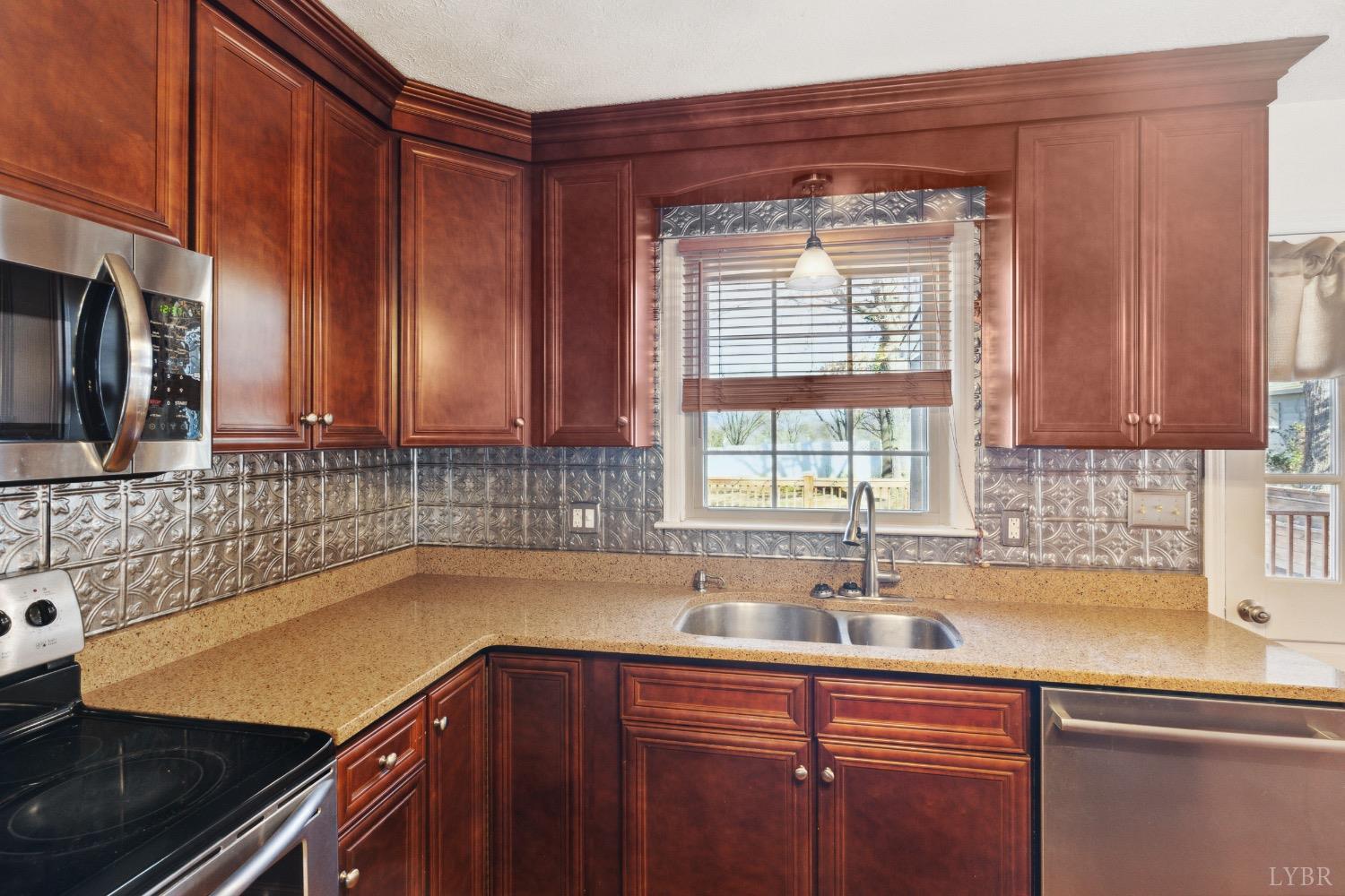 311 Bob Circle Forest, VA 24551 - Photo 34 of 61 a kitchen with stainless steel appliances a sink dishwasher a stove a microwave oven and a refrigerator with wooden cabinets