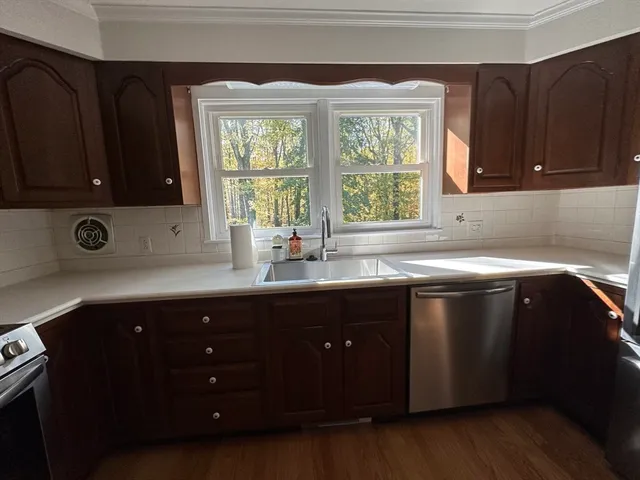 a kitchen with stainless steel appliances a sink a stove a refrigerator and cabinets