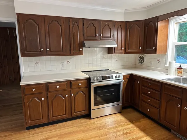 a kitchen with wooden cabinets and a stove top oven
