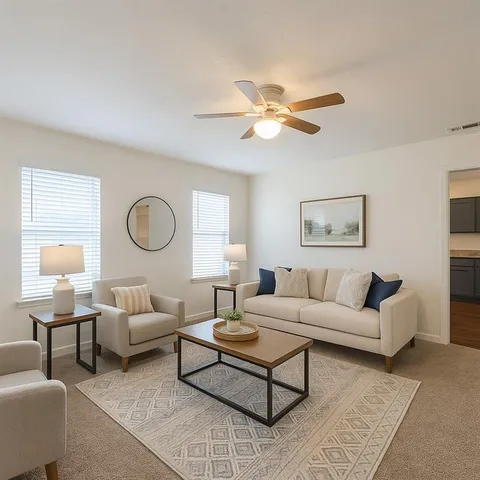 a living room with furniture a rug and a window