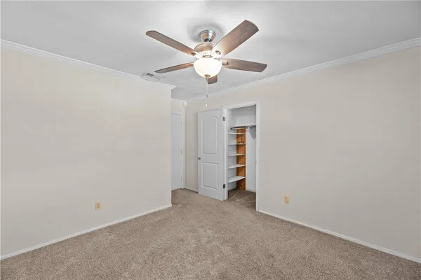 an empty room with closet and windows
