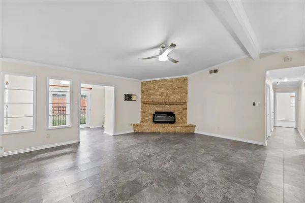 an empty room with windows and fireplace