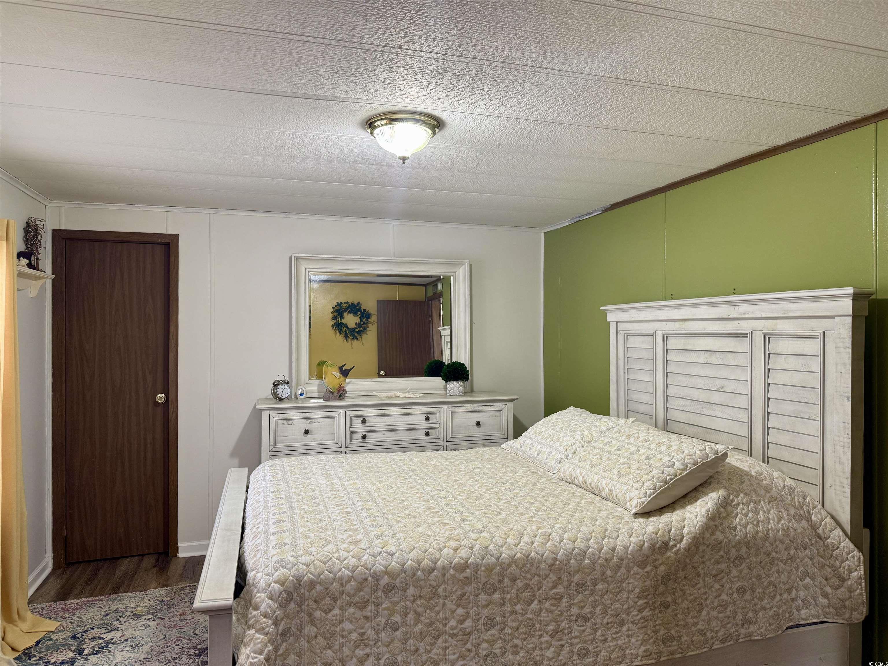 1801 E Lake Surfside Beach, SC 29575 - Photo 15 of 32 Bedroom with dark wood-style flooring, a textured ceiling, and ornamental molding