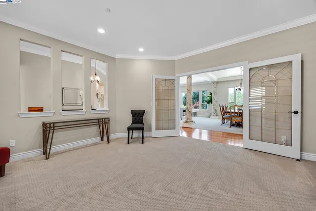 a kitchen with stainless steel appliances granite countertop a kitchen island a stove a refrigerator a oven and a dining table with wooden floor