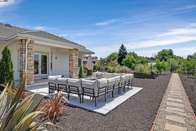 a view of a patio with couches table and chairs and potted plants