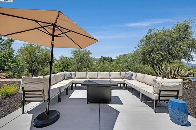 a view of a patio with a table and chairs under an umbrella