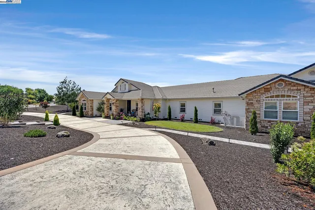 a front view of house with yard and trees in the background
