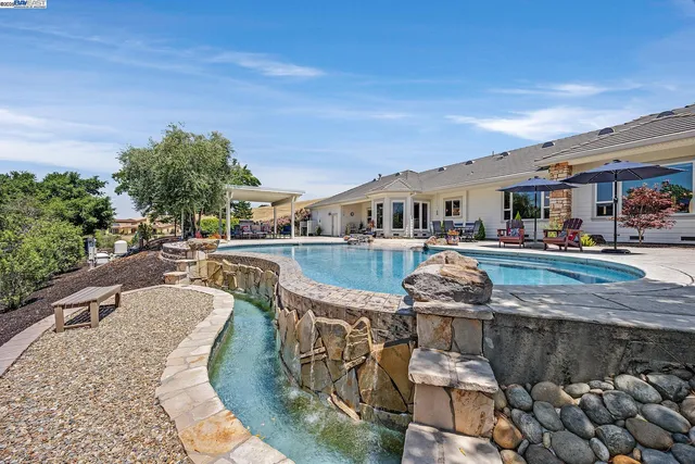 a view of a patio with a table and chairs under an umbrella