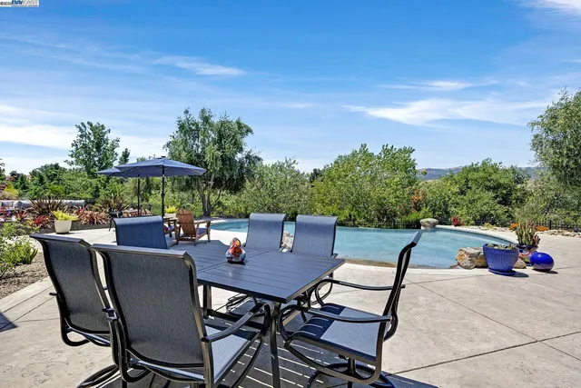 a view of a backyard with lawn chairs and a fire pit