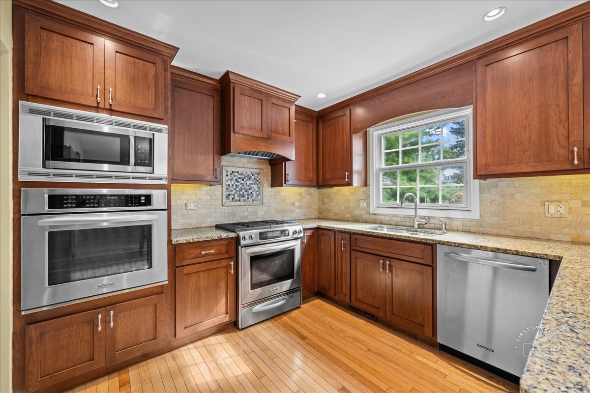 1432 Calcutta Lane Naperville, IL 60563 - Photo 12 of 43 a kitchen with granite countertop wooden cabinets stainless steel appliances and a window