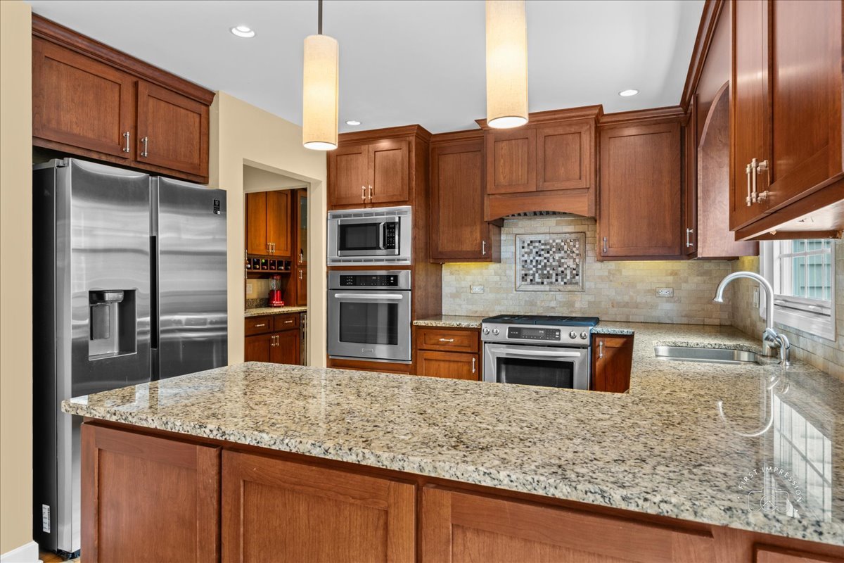 1432 Calcutta Lane Naperville, IL 60563 - Photo 14 of 43 a kitchen with stainless steel appliances granite countertop a sink stove and refrigerator