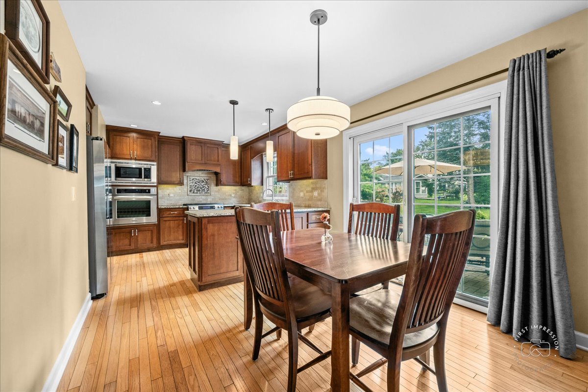 1432 Calcutta Lane Naperville, IL 60563 - Photo 15 of 43 a dining room with furniture a chandelier and wooden floor