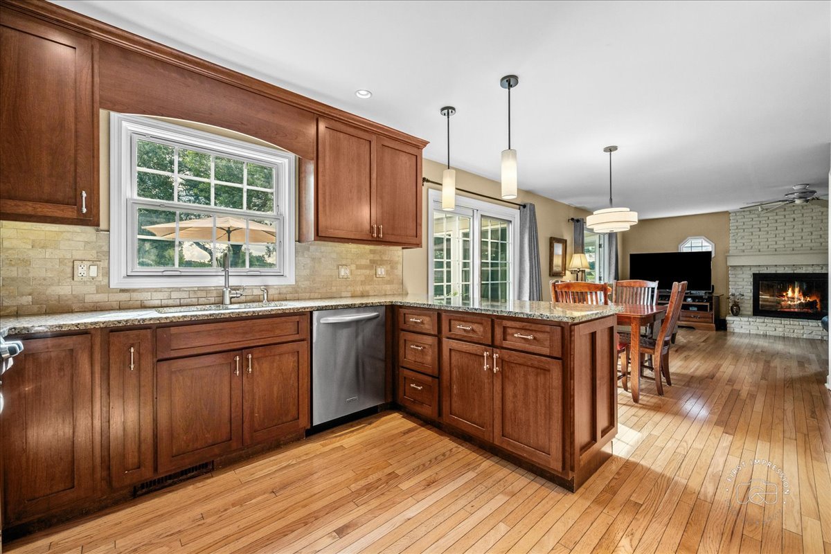 1432 Calcutta Lane Naperville, IL 60563 - Photo 10 of 43 a kitchen with stainless steel appliances granite countertop wooden floors wooden cabinets a sink a window and appliances