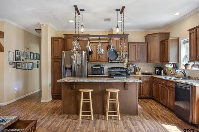 a kitchen with stainless steel appliances granite countertop wooden floors and white cabinets