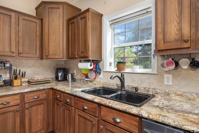 a kitchen with stainless steel appliances granite countertop a sink a stove and cabinets