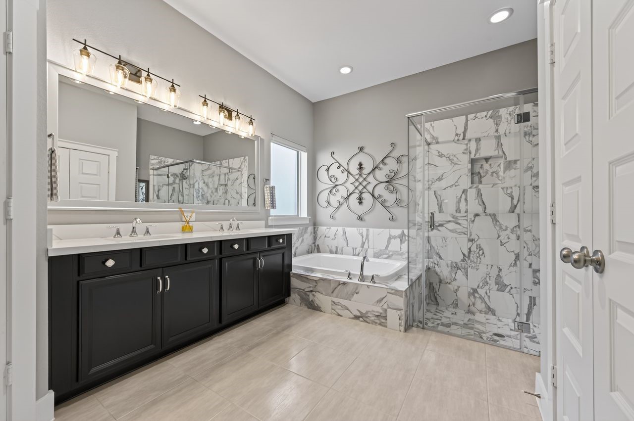 16707 Seminole Ridge Drive Cypress, TX 77433 - Photo 14 of 26 a spacious bathroom with a double vanity sink a toilet a mirror and shower