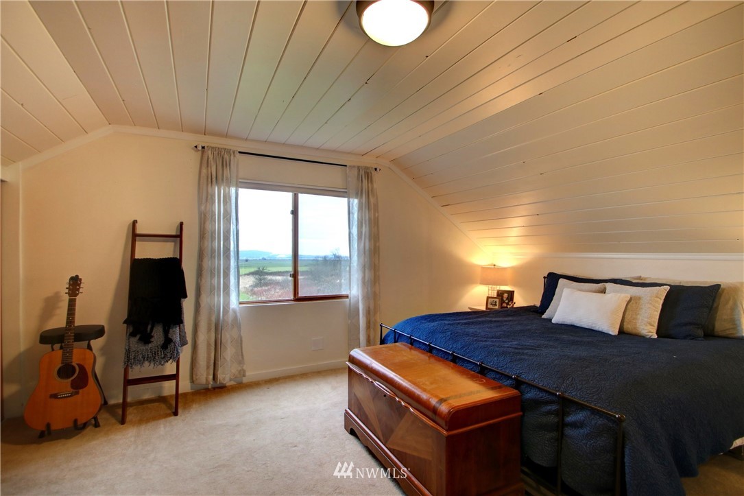 12814 Farm To Market Road Mount Vernon, WA 98273 - Photo 16 of 32 a bedroom with a bed and wooden floor