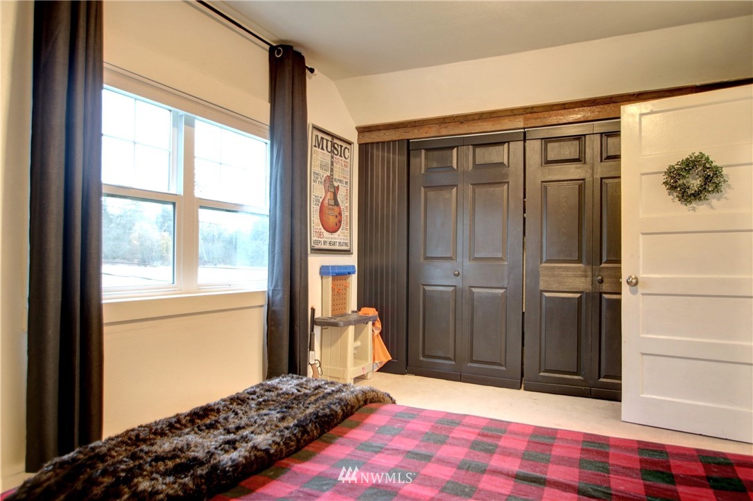 12814 Farm To Market Road Mount Vernon, WA 98273 - Photo 20 of 32 a bedroom with a bed and a dresser next to a window
