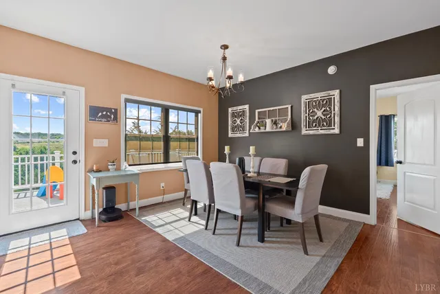 a view of a dining room with furniture a chandelier and wooden floor
