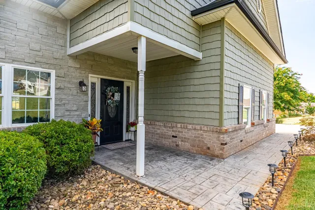 a view of a house with a small yard and potted plants