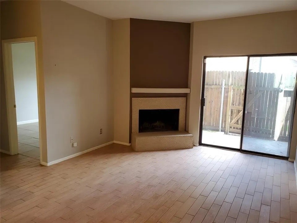 5000 Milwee Street, Unit 44 Houston, TX 77092 - Photo 3 of 16 a view of empty room with wooden floor and fireplace