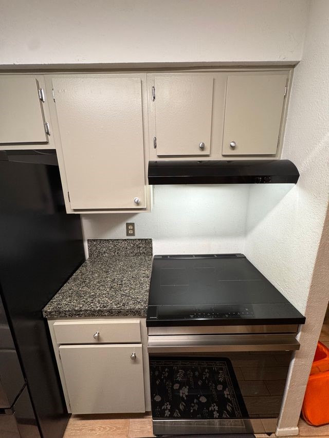 5000 Milwee Street, Unit 44 Houston, TX 77092 - Photo 9 of 16 a kitchen with white cabinets and black appliances