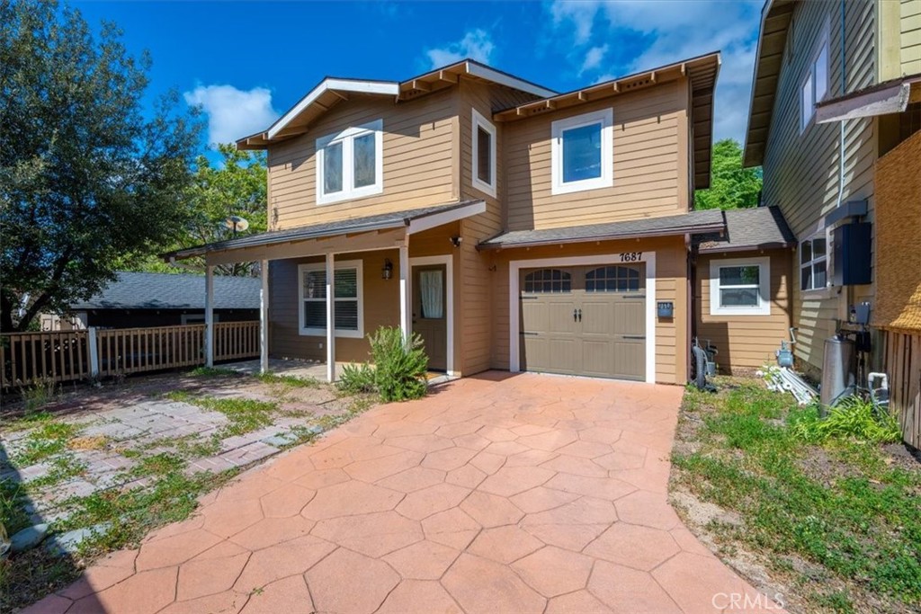 7687 Sinaloa Avenue Atascadero, CA 93422 - Photo 2 of 34 a front view of a house with a garden and trees