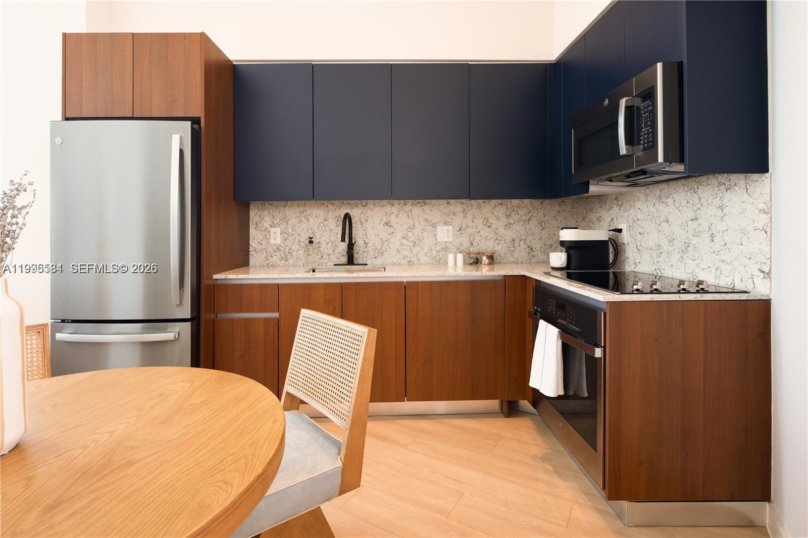 275 Southwest 6th Street, Unit 502 Miami, FL 33130 - Photo 2 of 19 a kitchen with stainless steel appliances a refrigerator a sink a stove top oven a refrigerator and cabinets